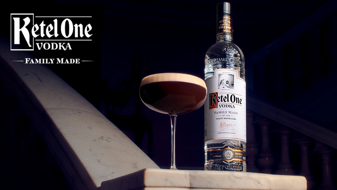 Two Ketel One Martinis next to a bottle of Ketel One Vodka.